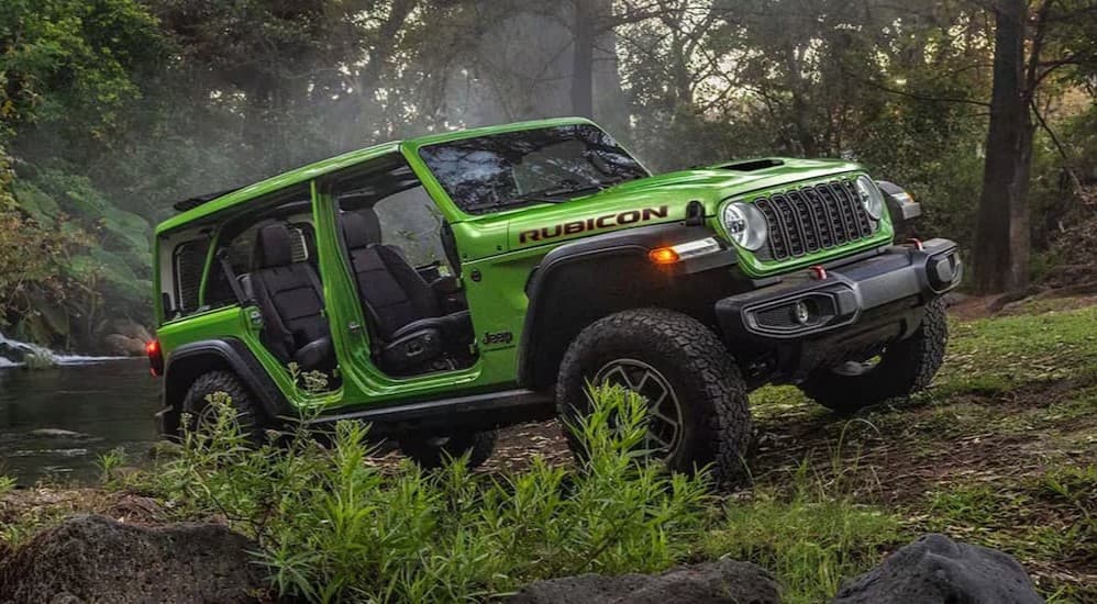 A green 2026 Jeep Wrangler parked off-road.