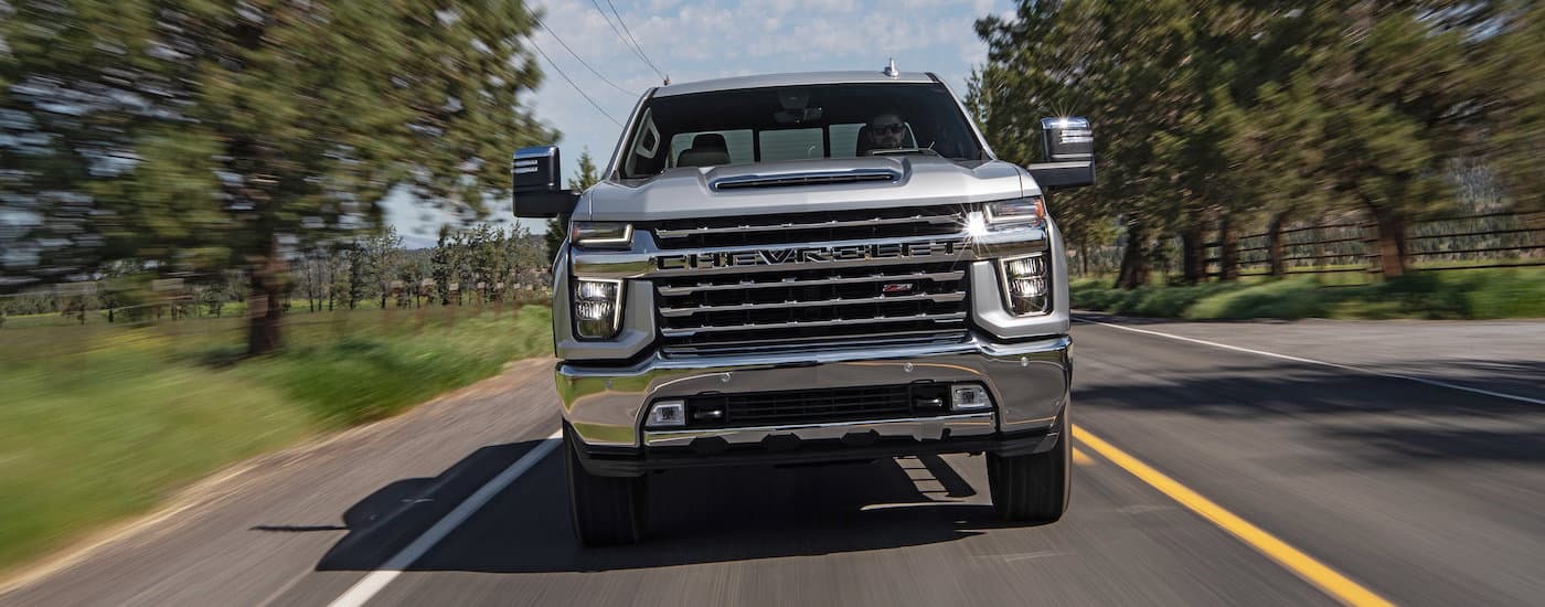 Head-on view of a silver 2020 Chevy Silverado 2500 HD Z71 driving down a road.