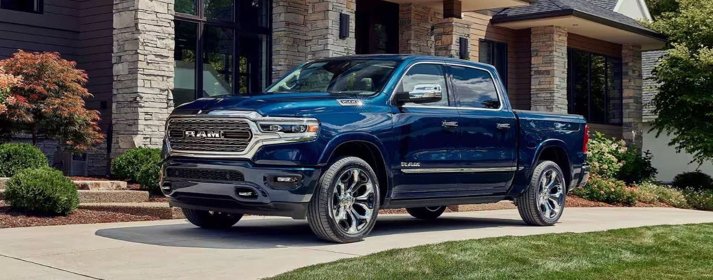 Blue 2023 Ram 1500 Limited Elite Edition parked in front of a house
