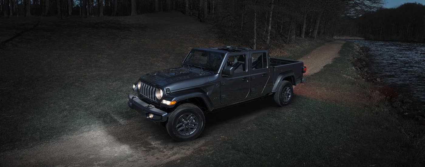 Grey 2026 Jeep Gladiator parked on a dirt road at night