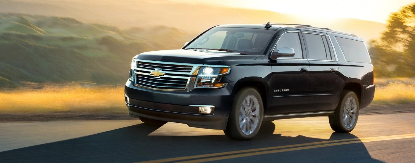 Black 2019 Chevy Suburban driving to a Chevy dealer