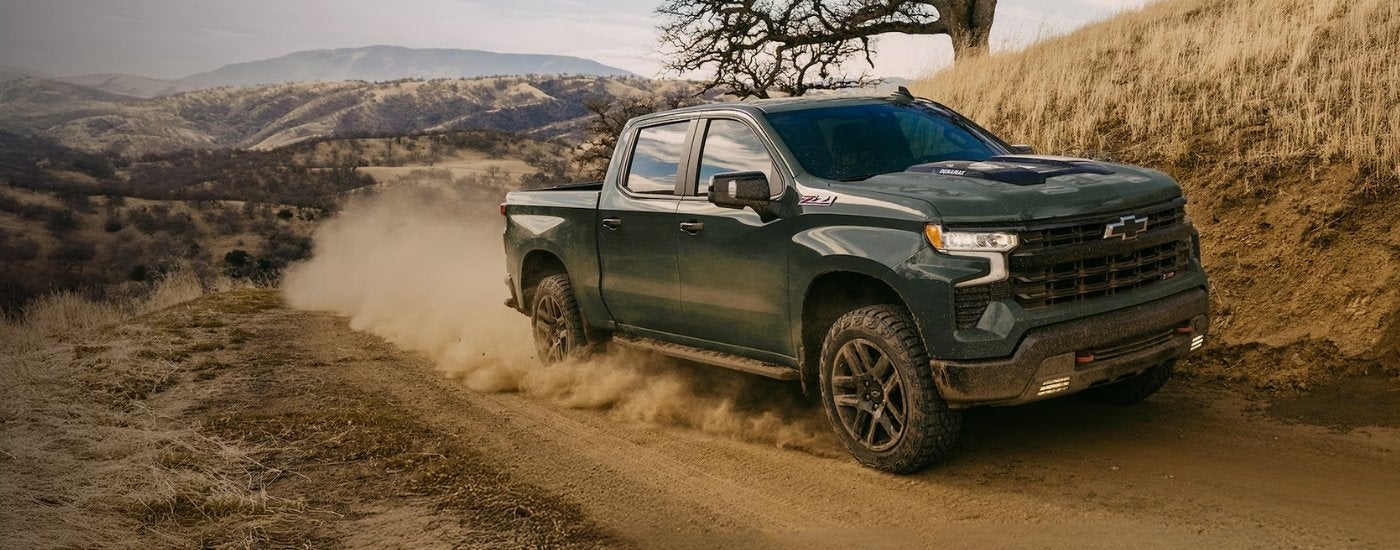 Dark grey 2025 Chevy Silverado 1500 Z71 driving on a dusty trail