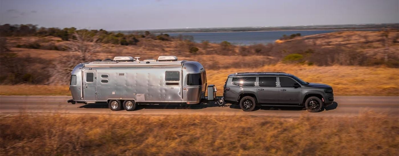 Grey 2025 Jeep Wagoneer driving to a Jeep dealer near Broken Bow