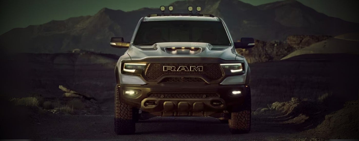 Silver 2024 Ram 1500 TRX is parked off-road at dusk