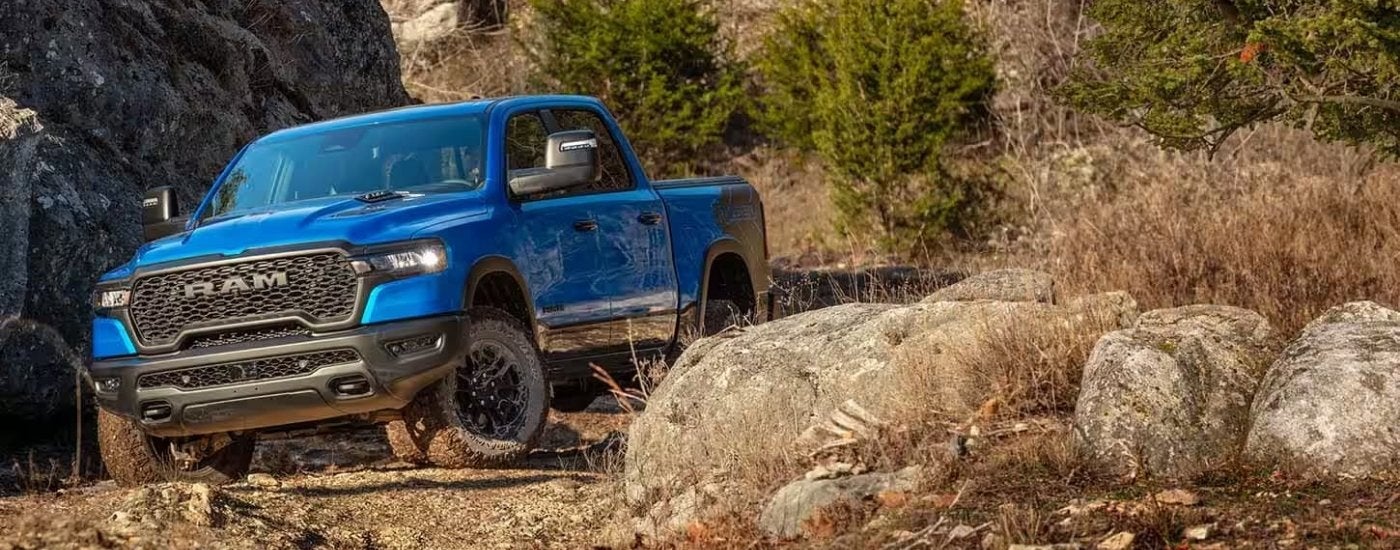 Blue 2025 Ram 1500 Rebel is parked near rocks