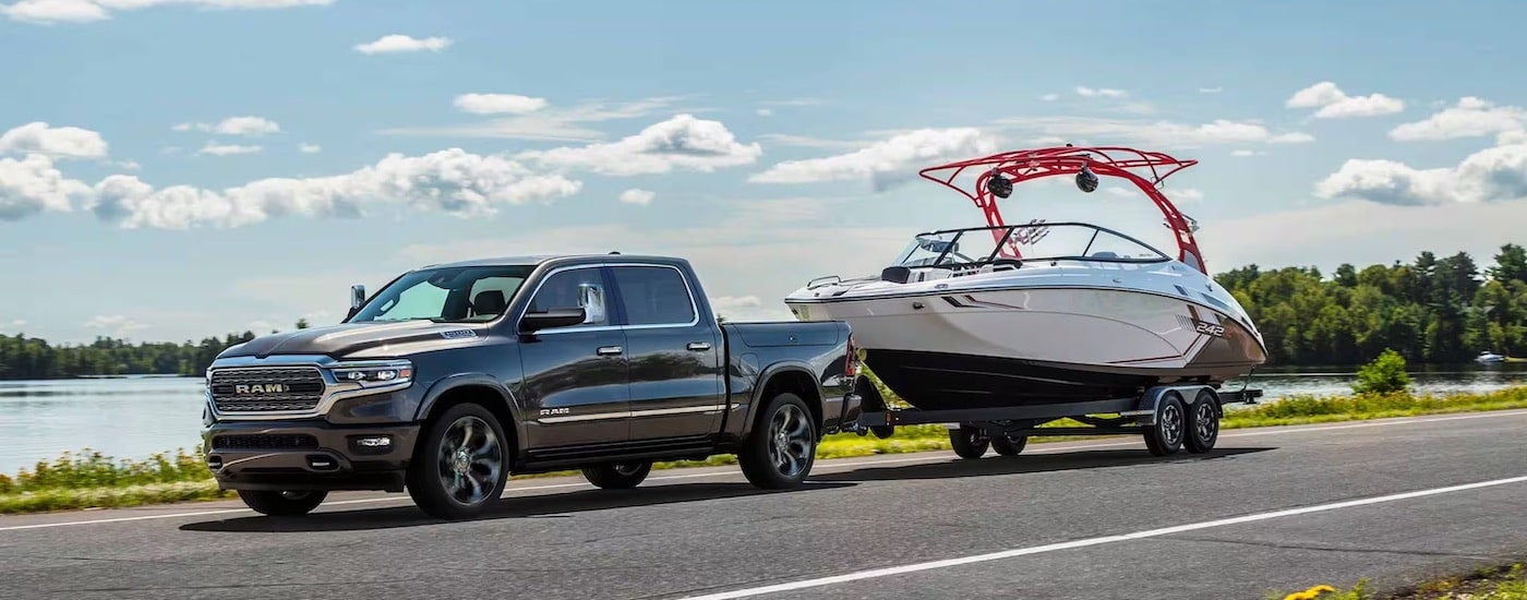 A grey 2024 Ram 1500 towing a boat after leaving a Ram dealer near Lexington.