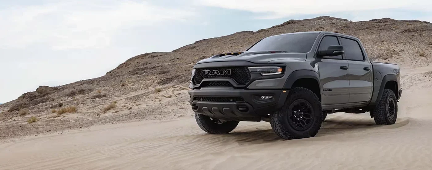 A grey 2023 Ram 1500 TRX Lunar Edition is parked off-road. A grey 2023 Ram 1500 TRX Lunar Edition is parked off-road.