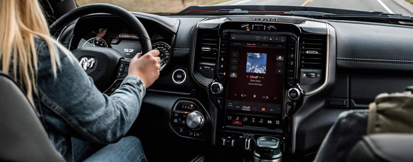 Woman driving in a used 2022 Ram 2500 truck for sale near Central City