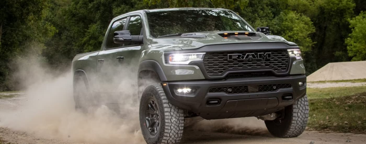 A gray 2026 Ram 1500 driving in dirt